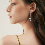Close-up of a woman wearing a floral earring with a plain background
