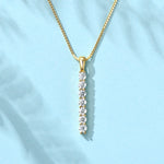 Gold necklace with a diamond pendant on a light blue background