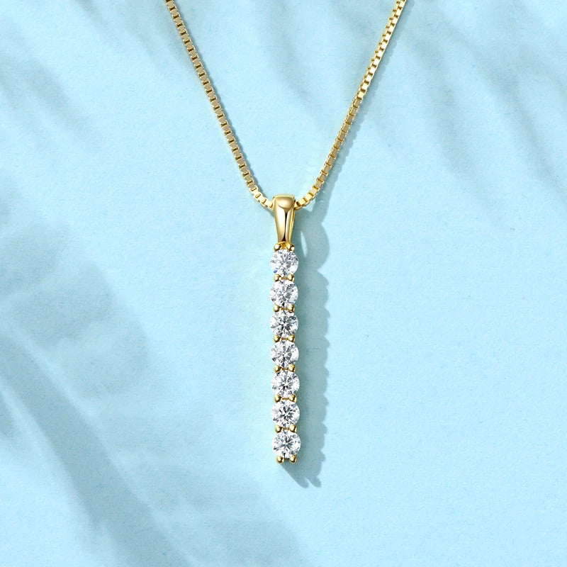 Gold necklace with a diamond pendant on a light blue background
