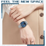 Hand wearing a watch with text 'Feel the New Space' on a beige background