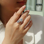 Close-up of a hand wearing a diamond ring with a blurred background