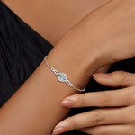 Silver bracelet with a diamond on a wrist against a neutral background
