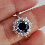 Ring with a black diamond and white gemstones on a hand