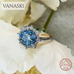 Silver ring with a blue gemstone on a white flower background, featuring the Vanaski brand.