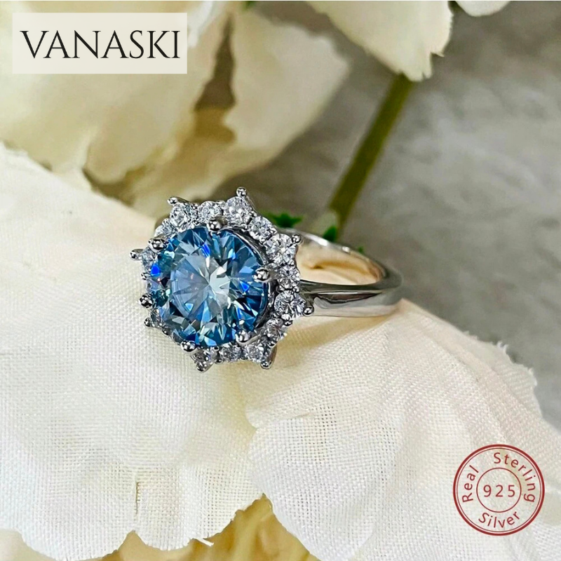 Silver ring with a blue gemstone on a white flower background, featuring the Vanaski brand.