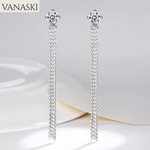 Silver tassel earrings with floral tops on a white background, branded 'VANASKI'.
