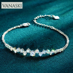 Silver bracelet with clear stones on a teal fabric background, featuring the Vanaski brand.