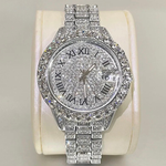 Silver watch with gemstone accents on a beige cushion