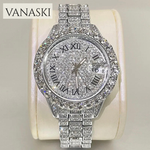 Silver watch with gemstones on a beige cushion, branded 'VANASKI'.