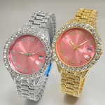 Two ornate wristwatches, one silver and one gold, with pink faces and diamond-studded bezels.