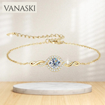 Gold bracelet with a diamond-like center on a marble stand, Vanaski brand visible.