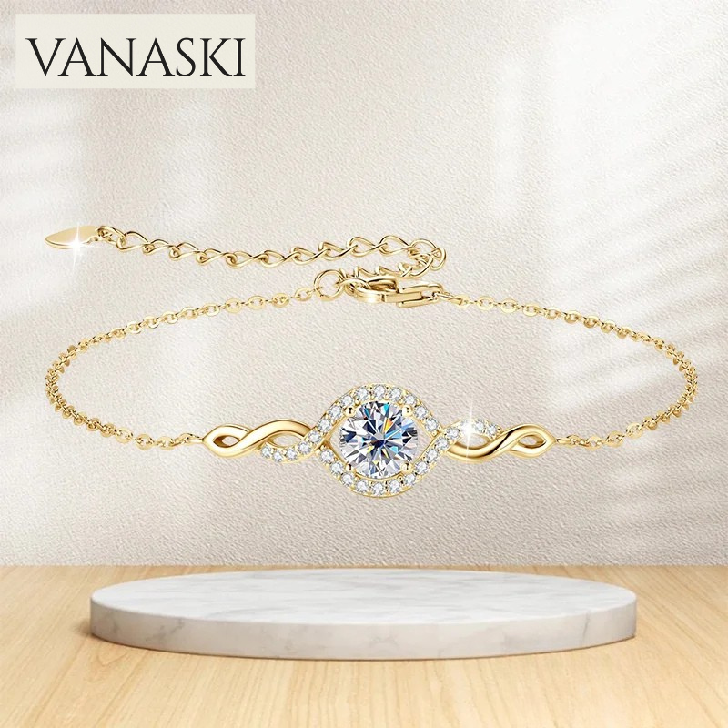Gold bracelet with a diamond-like center on a marble stand, Vanaski brand visible.