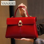 Red handbag with gold accents held by a person, featuring the Vanaski brand.